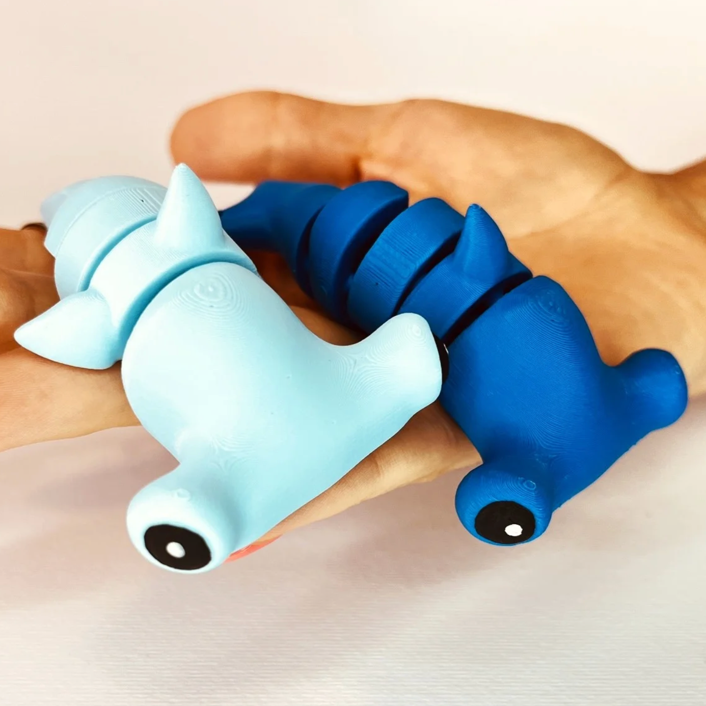Flexi Hammerhead Shark keychains in Light Blue and Royal Blue held in a hand