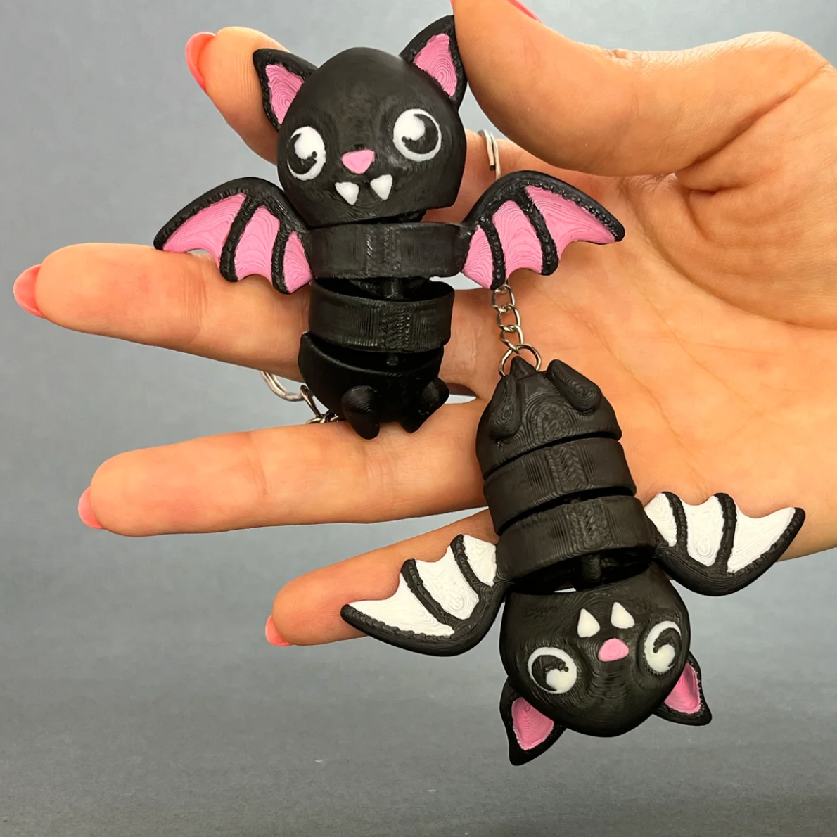 Close-up of Flexi Halloween Bat keychains in Pink Wings and White Wings colorways
