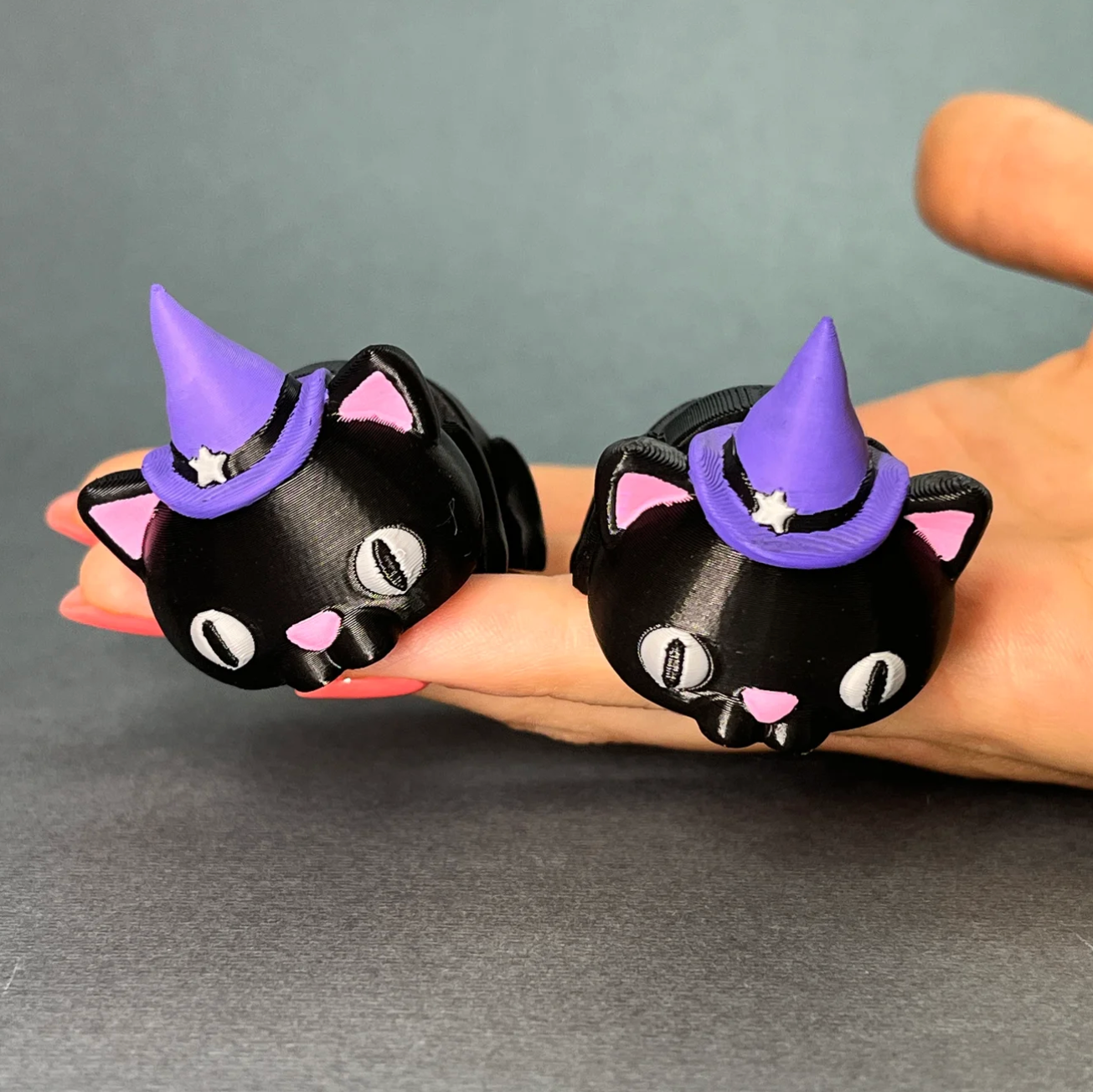 Flexi Halloween Cat keychains held in a hand