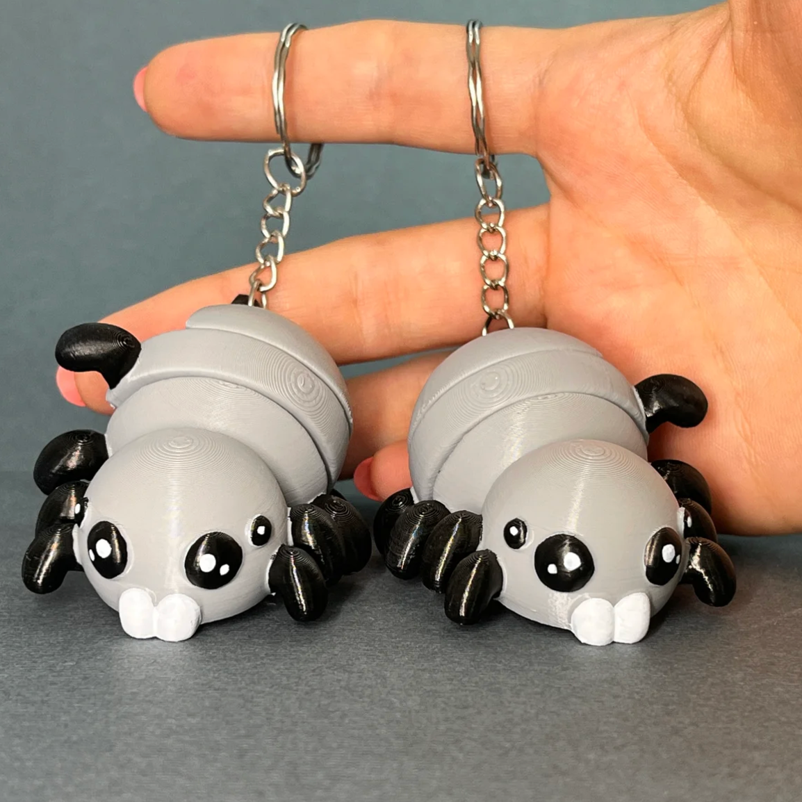 Flexi Halloween Spider keychains in White/Grey colorway held in a hand